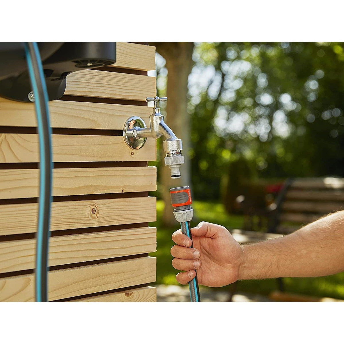 Wall-Mounted Hose Box RollUp XL 35m Gardena with chrome faucet and blue hose on wooden wall on Tampa Home & Garden Store