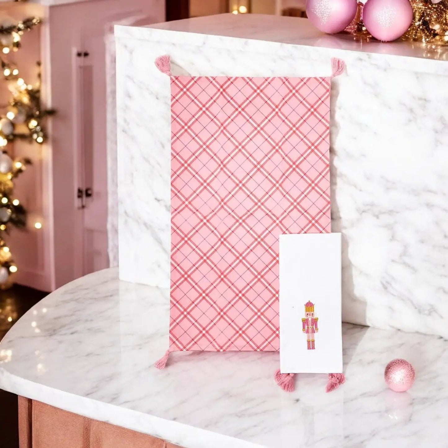 Nutcracker Tea Towel Pink plaid dish towel with tassels on marble counter on Tampa Home & Garden Store