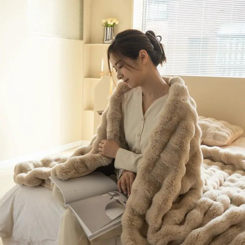 Double-Sided Faux Fur Rabbit Throw Blanket in beige cream draped over a woman on a bed, plush on Tampa Home & Garden Store
