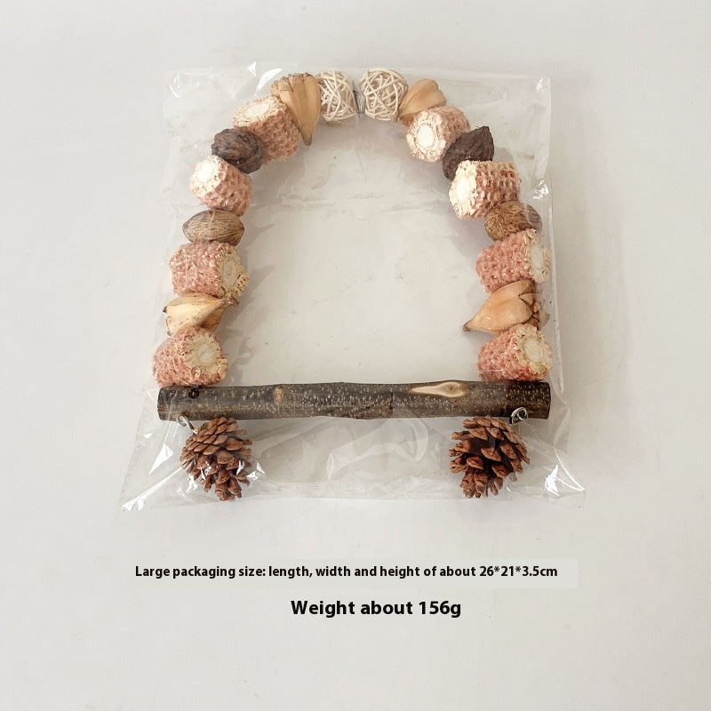 Wooden parrot swing natural log bird stand with pinecone accents in clear packaging on Tampa Home & Garden Store