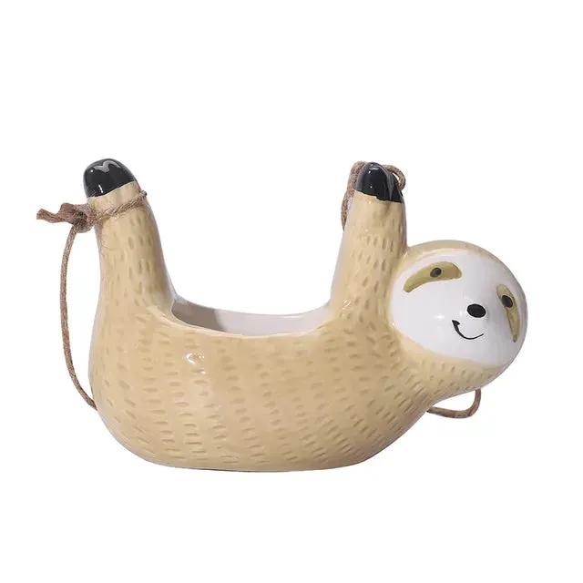 Sloth-shaped ceramic hanging planter with beige textured body and white face, rope hangers on Tampa Home & Garden Store