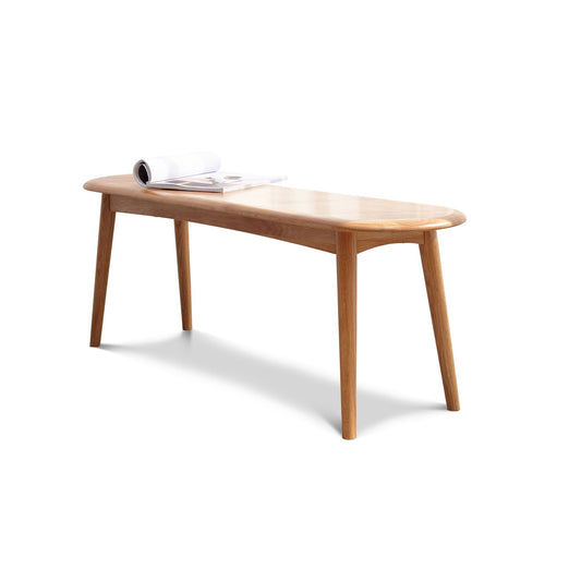Dining bench in light oak wood with rounded edges and tapered legs, magazine on top on Tampa Home & Garden Store