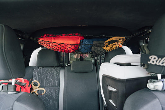 Flatirons Overland Toyota Tacoma Attic Storage Net in black, secures red and blue bags in SUV on Tampa Home & Garden Store