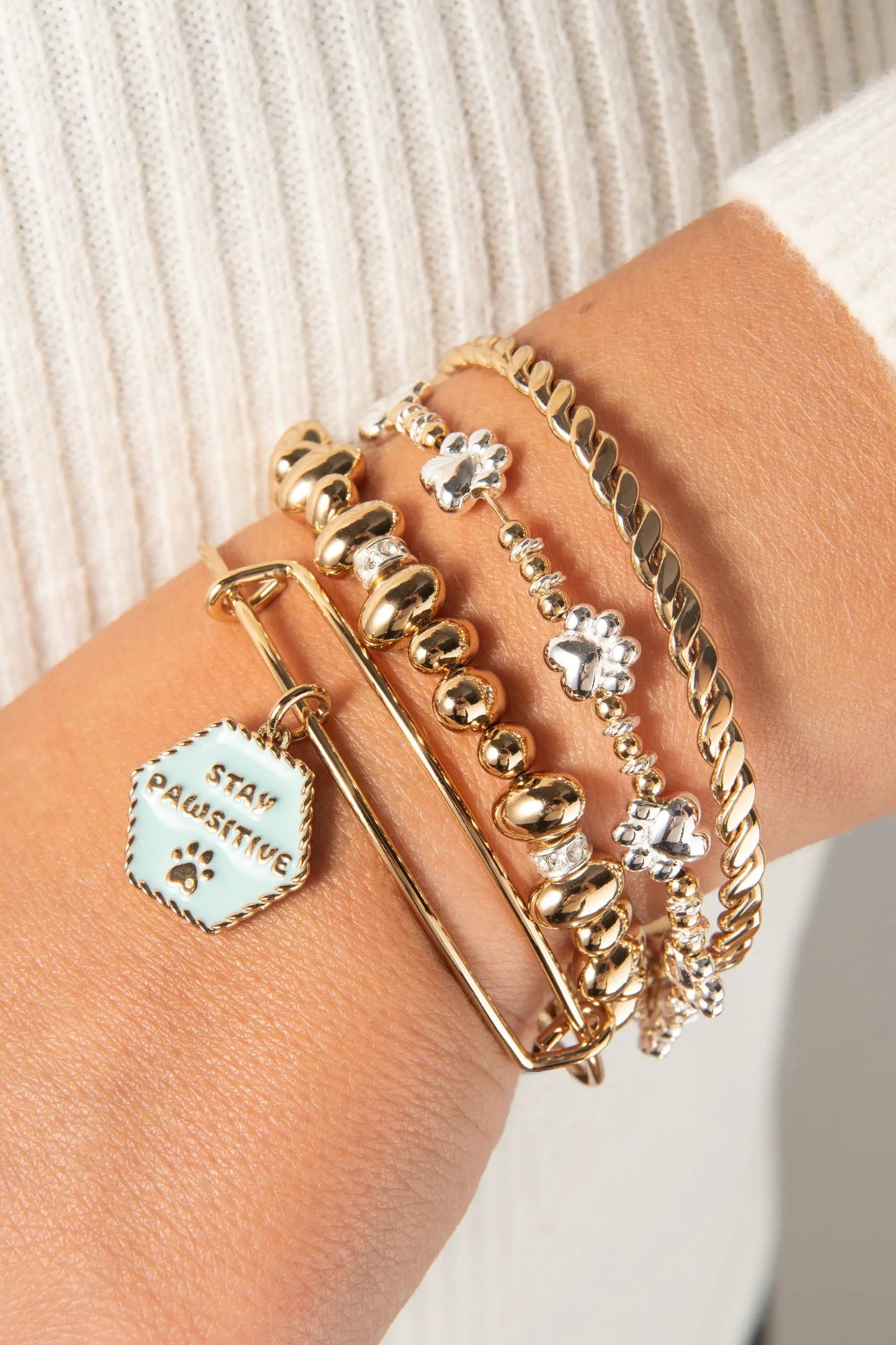 Paw Print Beaded Dog Bangle with turquoise charm among mixed gold-tone bracelets on Tampa Home & Garden Store