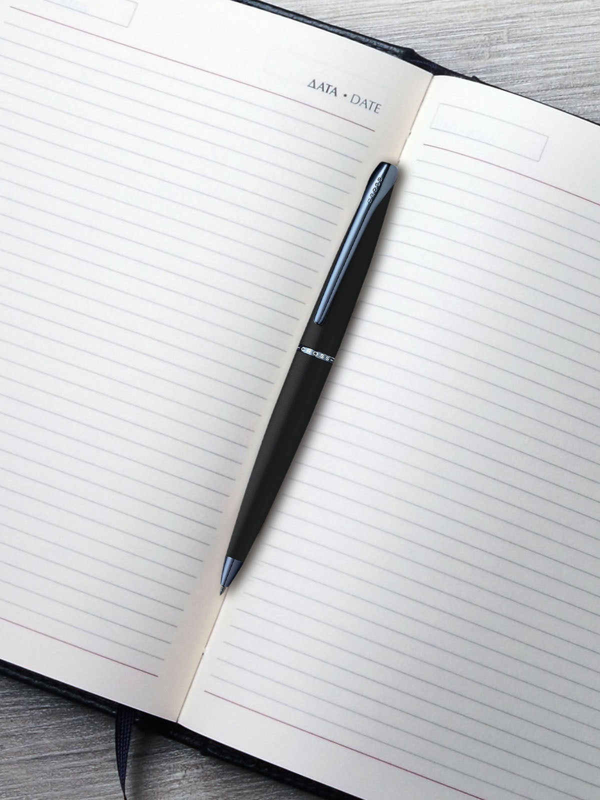 ATX Basalt Black ballpoint pen with blue PVD clip by A.T. Cross on lined notebook page on Tampa Home & Garden Store