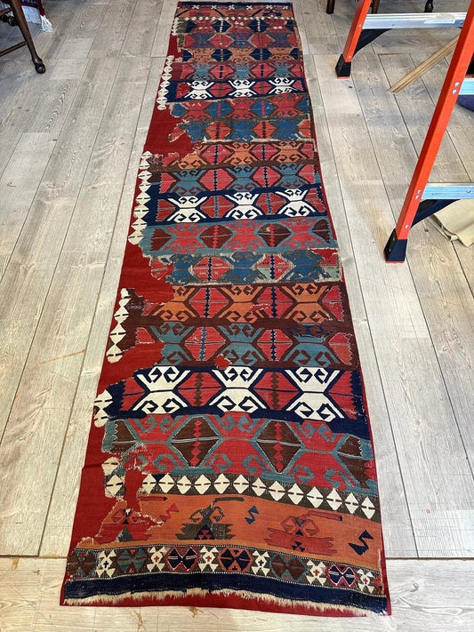Rugistan fragment rug: 19th c Anatolian kilim with red blue diamonds on wood floor on Tampa Home & Garden Store