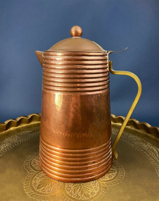 Antique copper coffee pot with ribbed body, brass handle and domed lid on a decorative tray on Tampa Home & Garden Store
