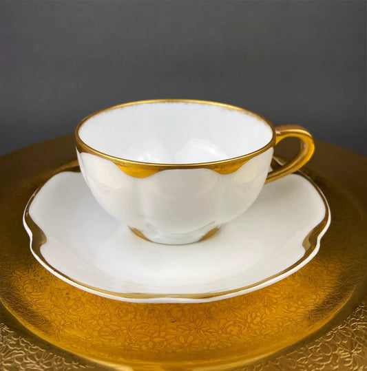Antique Limoges white porcelain teacup and saucer trio with gilded rims on a gold charger on Tampa Home & Garden Store
