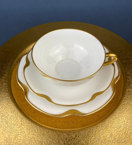 Antique Limoges teacup and saucer on a gold charger, white porcelain with gold trim on Tampa Home & Garden Store