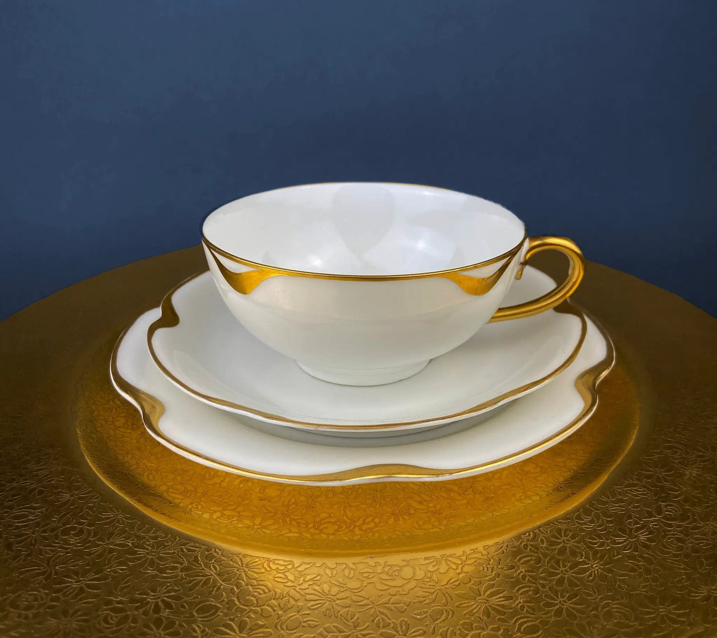Antique Limoges teacup and saucer with gold trim, white porcelain, gold handle on charger on Tampa Home & Garden Store