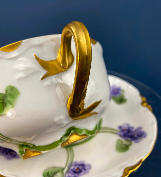 Antique teacup and saucer in white porcelain with violet floral motif and gold trim on Tampa Home & Garden Store