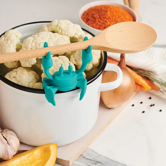 Aqua silicone utensil rest by OTOTO DESIGN in teal crab shape on white pot with wooden spoon on Tampa Home & Garden Store