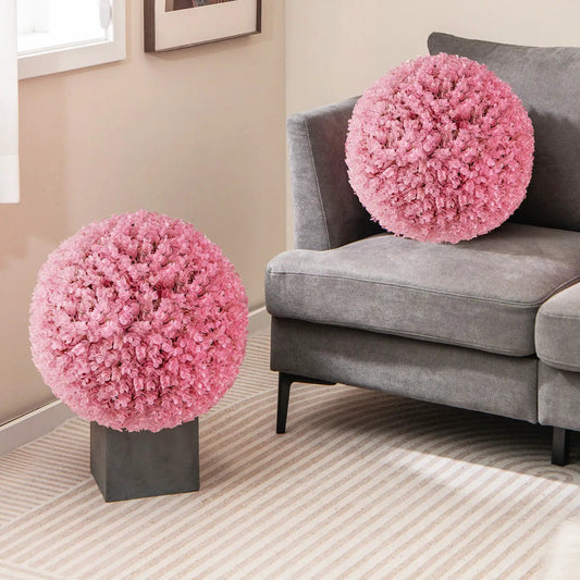 Pair of 17.5 inch pink faux purple eucalyptus decorative balls on a pedestal beside a gray sofa on Tampa Home & Garden Store