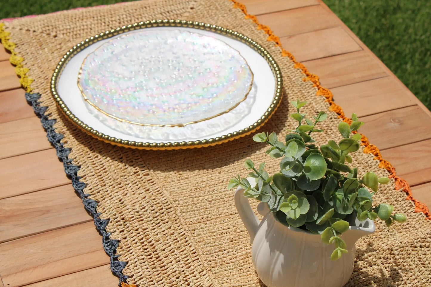 Aura Raffia Table Runner with Colorful Edges on a wooden outdoor table on Tampa Home & Garden Store