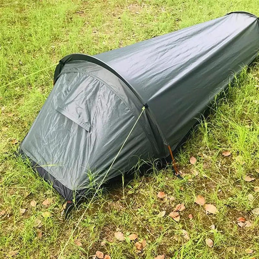 Lightweight one-person dome tent in dark gray, pitched on grassy ground on Tampa Home & Garden Store