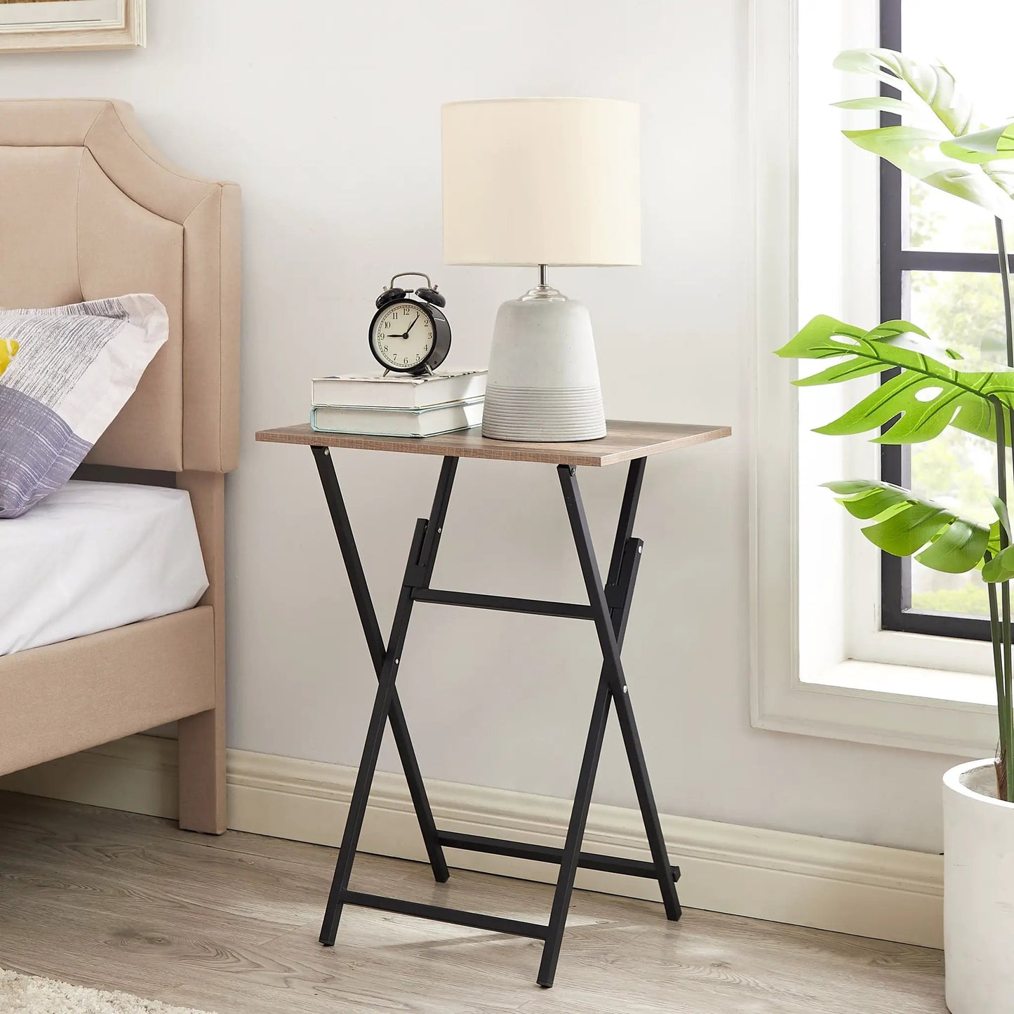 Rustic dining tray foldable table with brown top and black metal legs beside a bed on Tampa Home & Garden Store