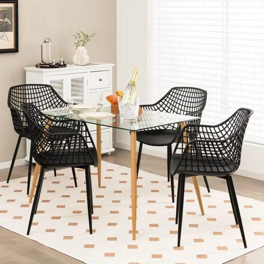 Set of four mid-century modern black mesh dining chairs with wooden legs on Tampa Home & Garden Store