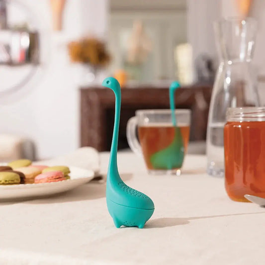 Baby Nessie Tea Strainer turquoise OTOTO DESIGN dinosaur-shaped infuser on a kitchen counter on Tampa Home & Garden Store