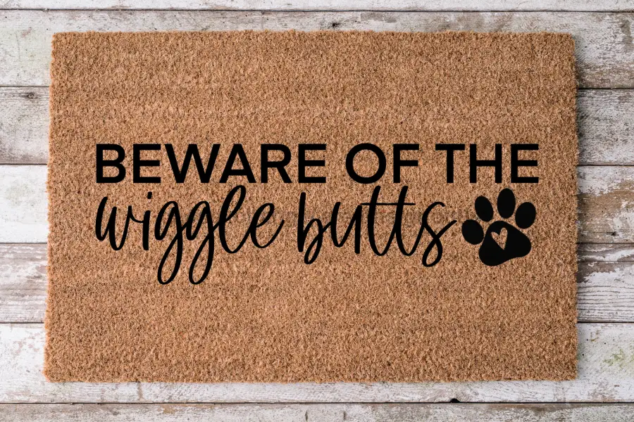 Coir dog door mat featuring Beware of the wiggle butts text and paw print natural brown on Tampa Home & Garden Store