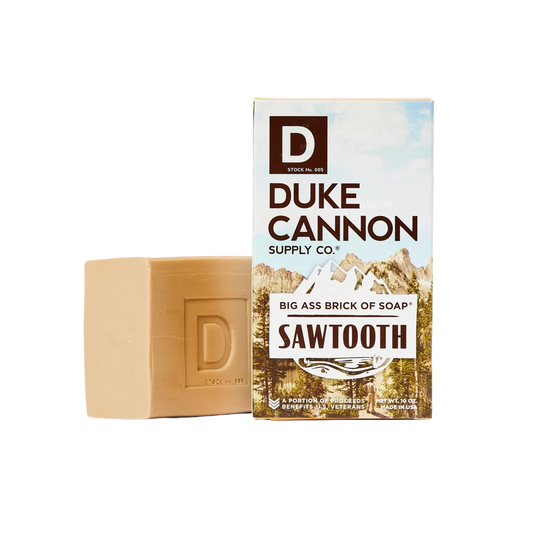 Duke Cannon Sawtooth Big Ass Brick Soap, beige brick beside its mountain-themed box on Tampa Home & Garden Store