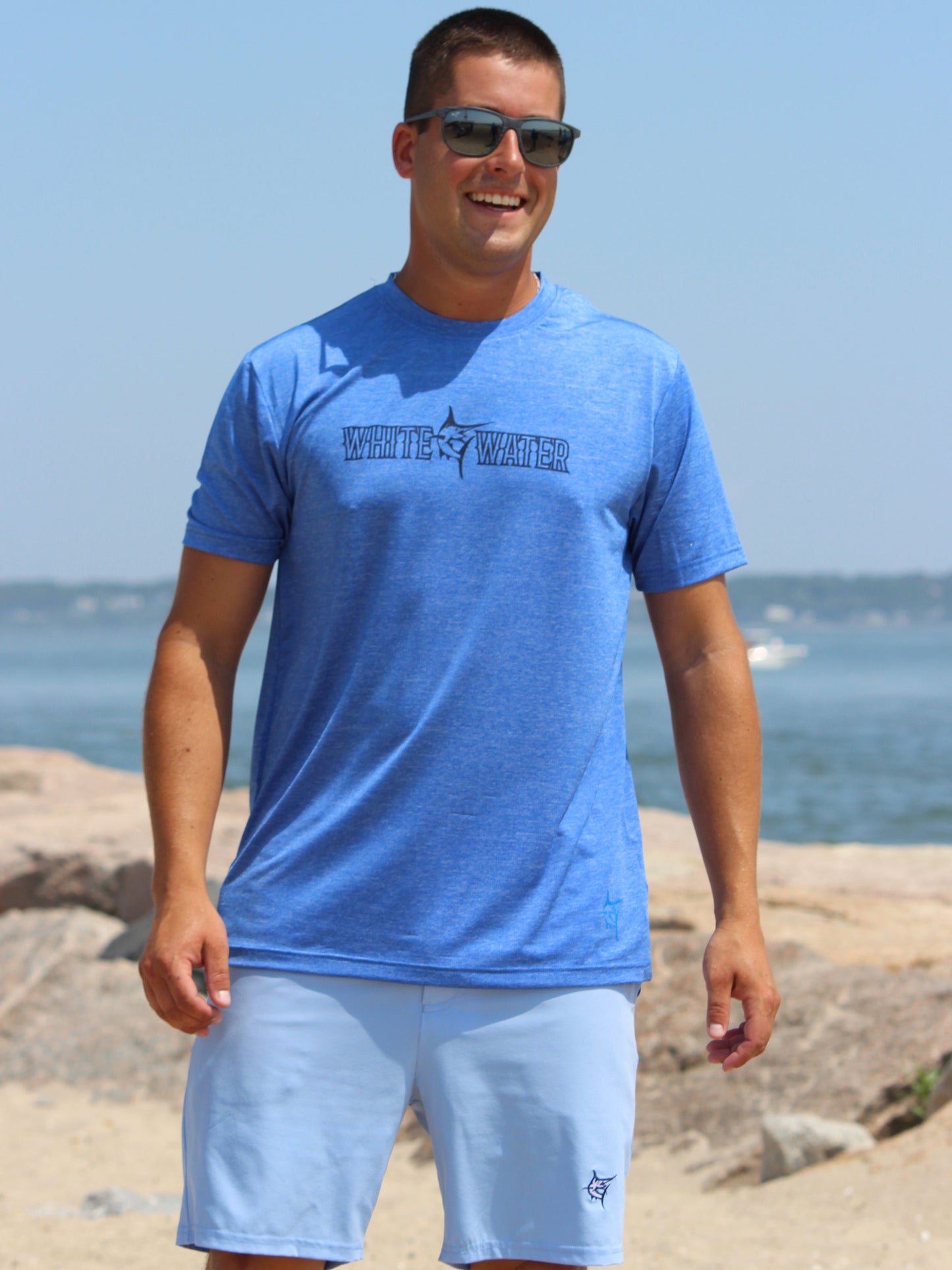Bimini Primary Performance Tee, blue short-sleeve shirt by White Water Life with logo on beach on Tampa Home & Garden Store