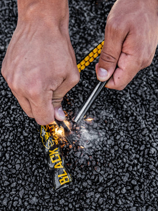 Black Beards Ferro Rod Fire Starter with yellow braided paracord, hands lighting sparks on Tampa Home & Garden Store