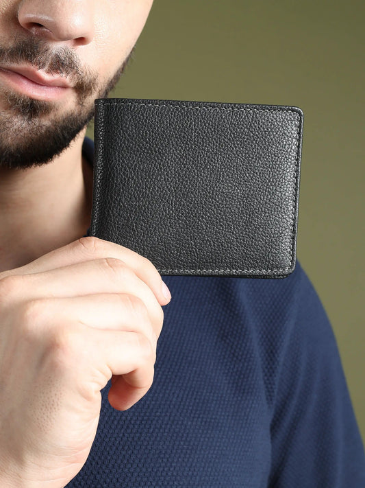 Men's black textured leather wallet held up close with visible edge stitching on Tampa Home & Garden Store