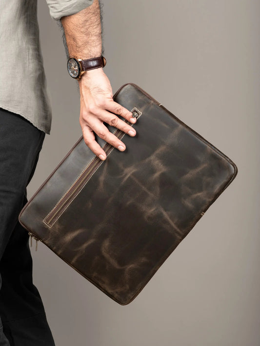 Brown leather laptop sleeve with secure zipper held in hand; Classy Leather Bags sleeve on Tampa Home & Garden Store