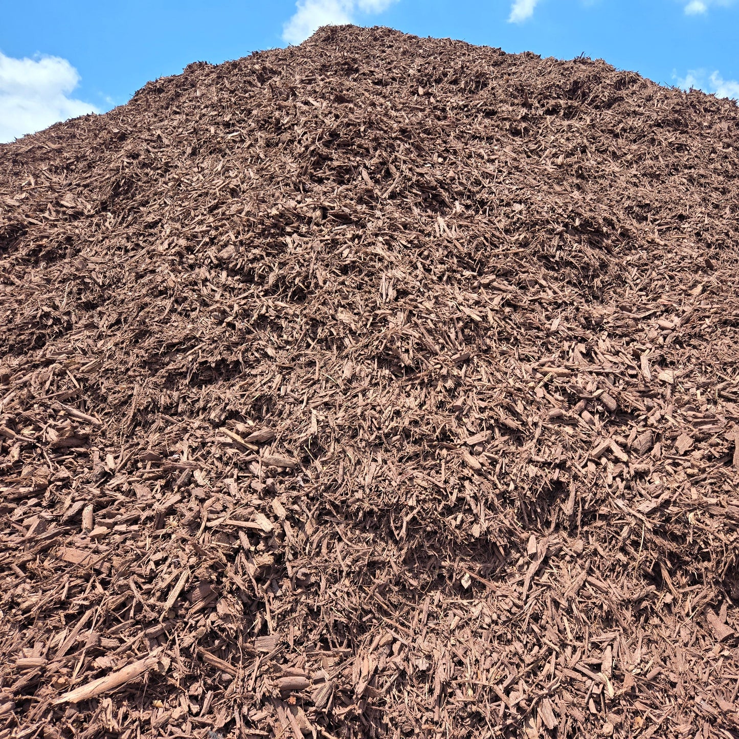 Pile of brown mulch for sale per cubic yard pricing.