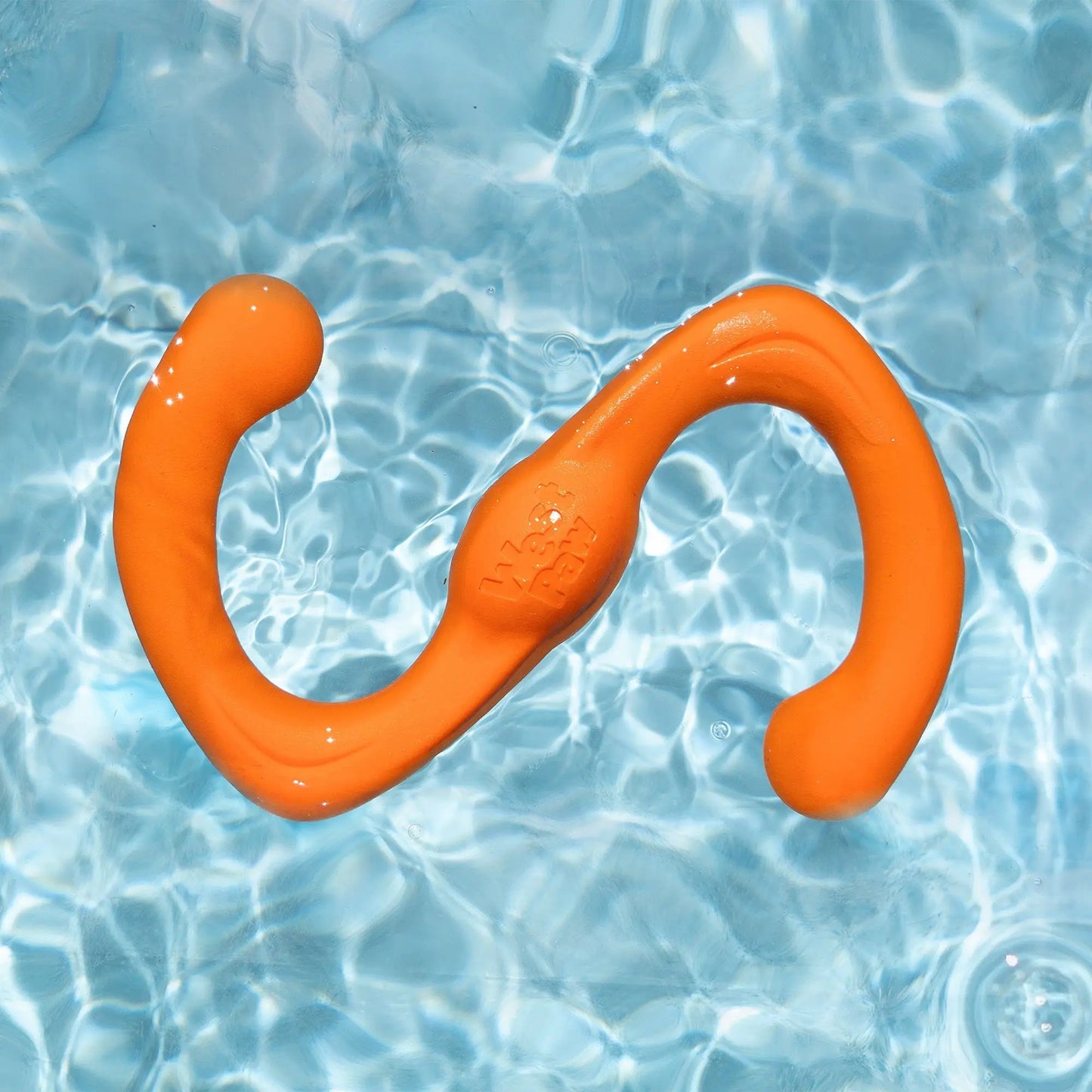 Bumi Ruby Stretch Toy for Gentle Chewers orange rubber dog toy by West Paw in pool water on Tampa Home & Garden Store