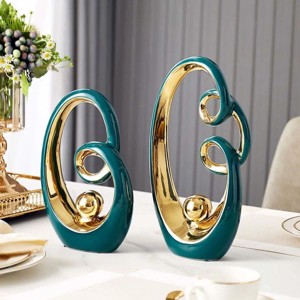 Decorative teal and gold abstract loop sculptures, set of 2 ceramic accents on a white table on Tampa Home & Garden Store
