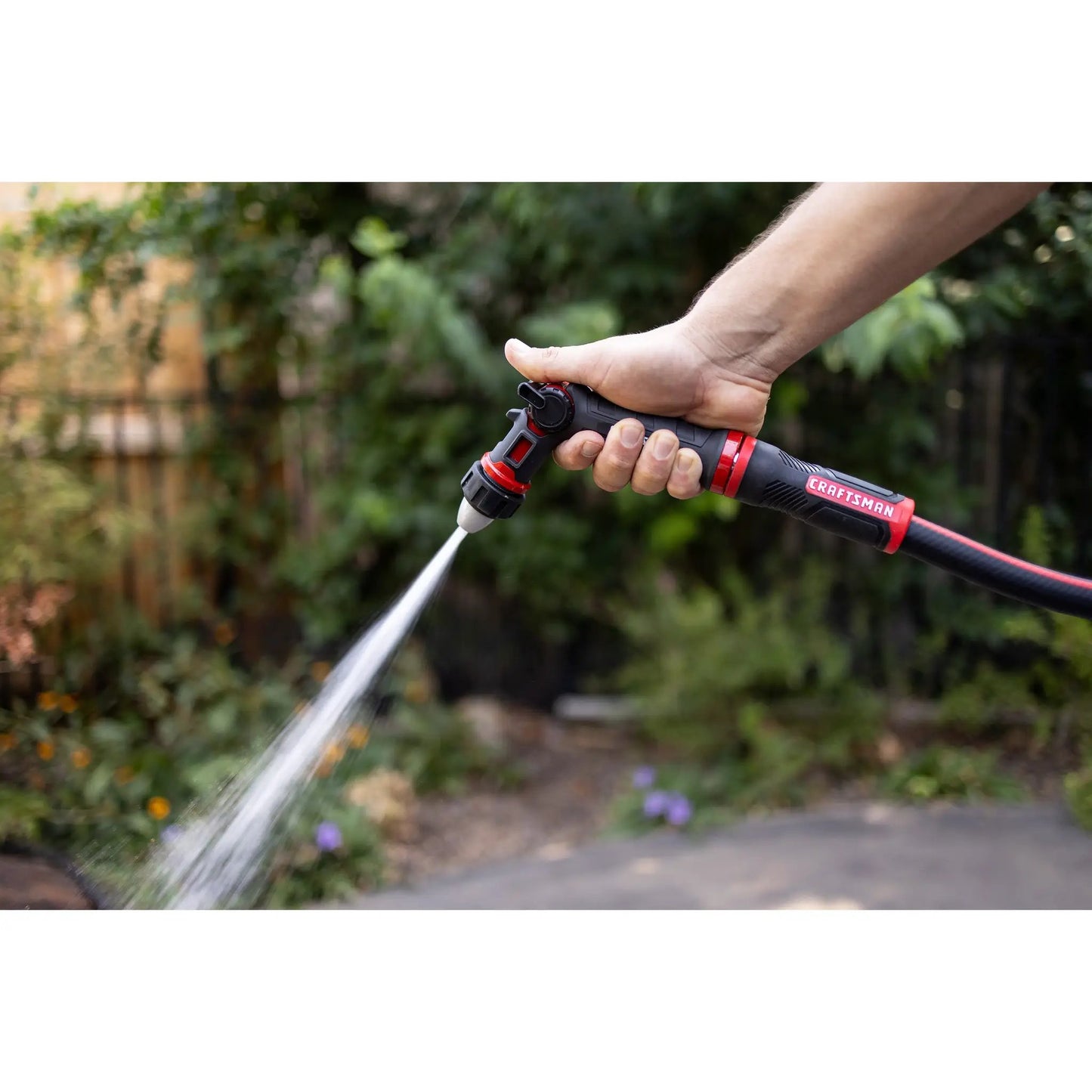 Craftsman Polyfusion 50ft garden hose 5/8in with red/black handle nozzle spraying water on Tampa Home & Garden Store