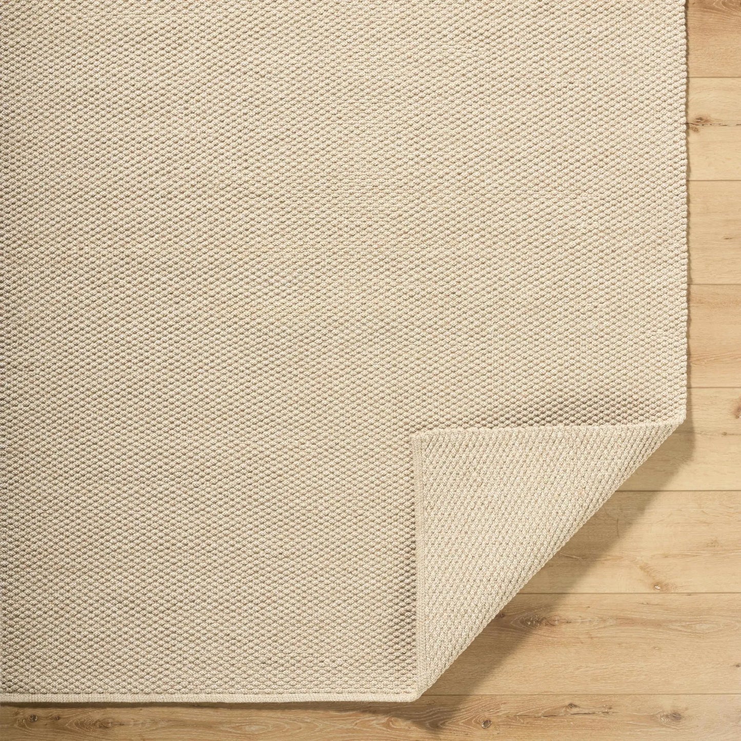 Cezary Jute Rug by Boutique Rugs, natural beige woven texture on wood floor on Tampa Home & Garden Store