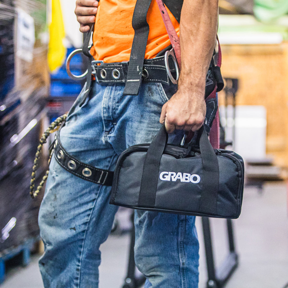 GRABO canvas carry bag in black with white GRABO logo, attached to a worker's tool belt on Tampa Home & Garden Store