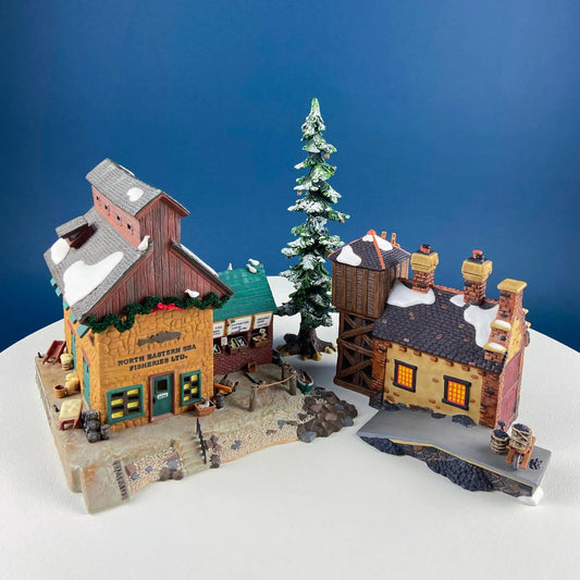 Christmas Village 2-Building Complex houses; snowy roofs, colorful storefronts, pine tree on Tampa Home & Garden Store