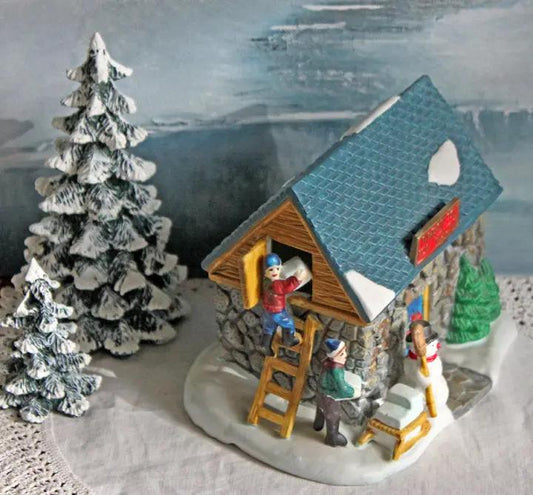 Frost's Ice House Towne Christmas Village with blue roof snow on stone base and figures with trees on Tampa Home & Garden Store