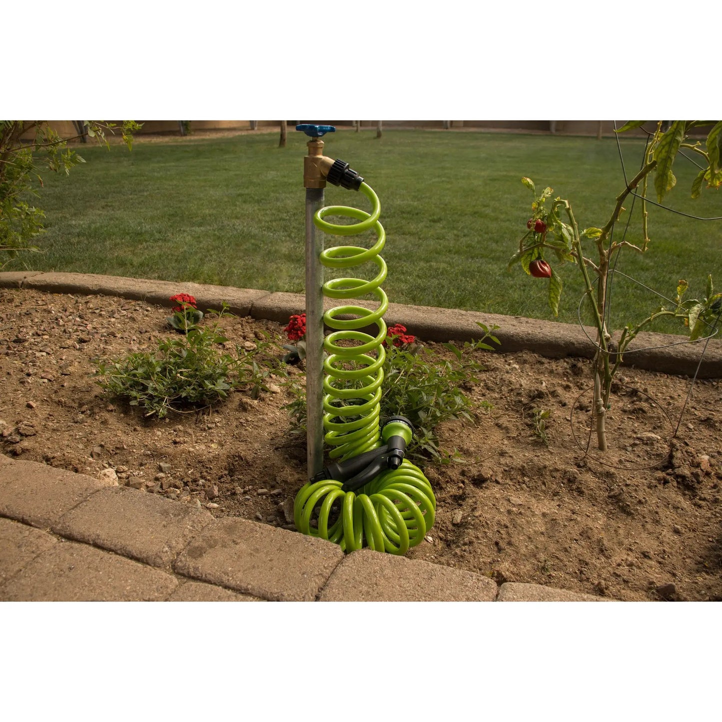 Green coil garden hose with 8-pattern nozzle Orbit Irrigation in a backyard on Tampa Home & Garden Store