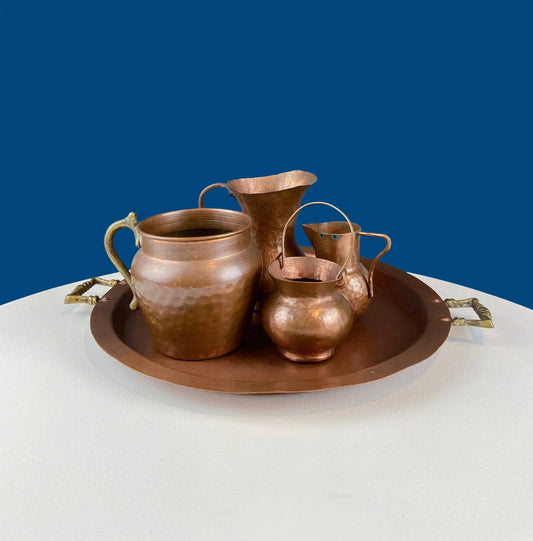 Vintage copper vases with brass handles arranged on a round copper tray on Tampa Home & Garden Store