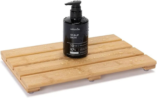 Compact bamboo bath mat with natural wood slats and small legs, topped by a black pump bottle on Tampa Home & Garden Store