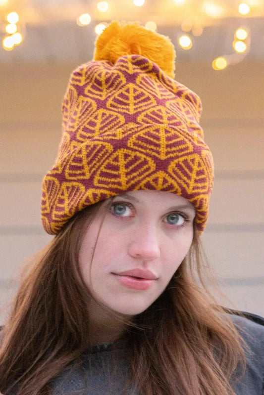 Crimson Glow Winter Hat with Beanie purple-yellow knit pattern with yellow pompom on a woman on Tampa Home & Garden Store