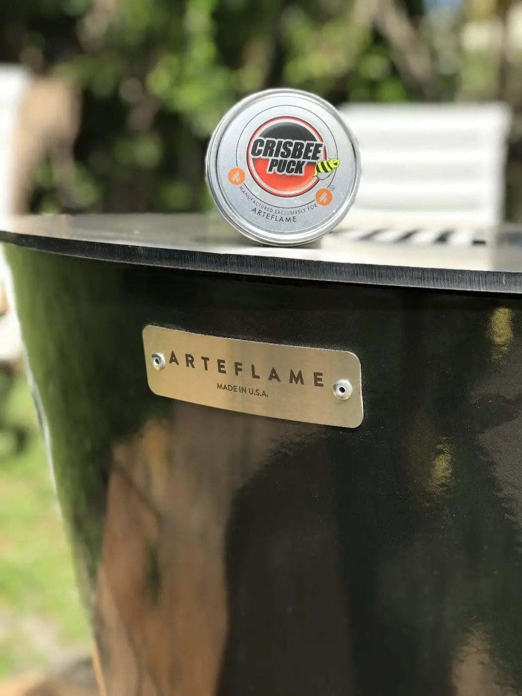 Crisbee Griddle Seasoning Puck on a black Arteflame grill, non-stick tin with red label on Tampa Home & Garden Store