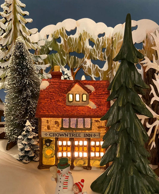 Crowntree Inn Christmas Village House by Dept 56, illuminated cottage amid snowy trees on Tampa Home & Garden Store