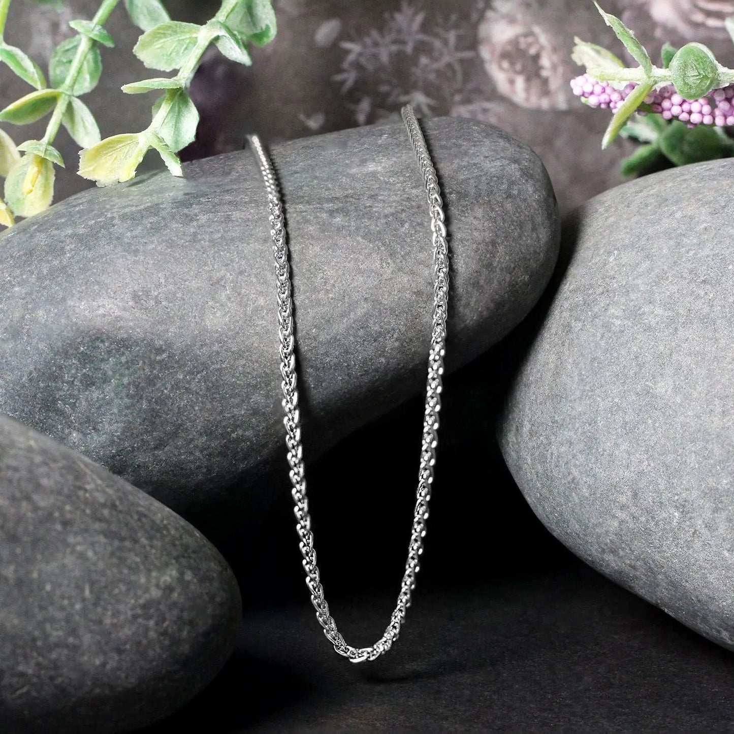 2.1mm white gold round wheat chain necklace draped over smooth gray stones on Tampa Home & Garden Store