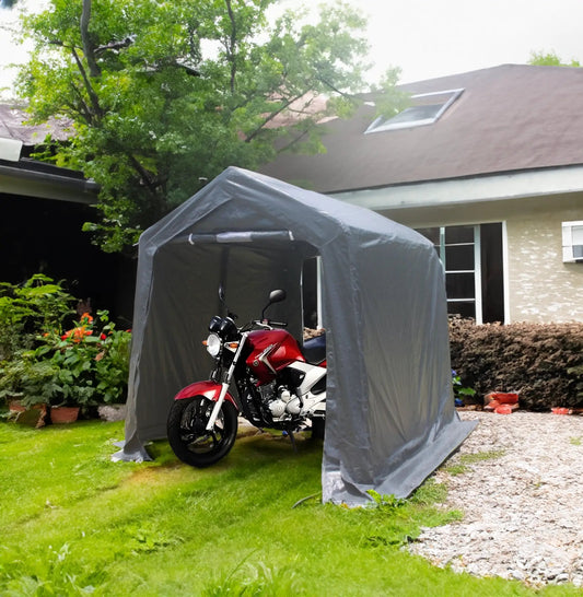 Outdoor portable gray gazebo shelter with 2 doors covering a red motorcycle in a yard on Tampa Home & Garden Store