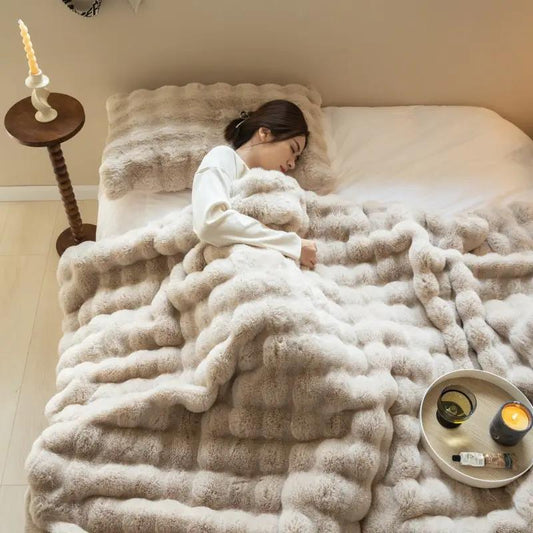Double-Sided Faux Fur Rabbit Throw Blanket beige plush blanket on bed with a woman resting on Tampa Home & Garden Store