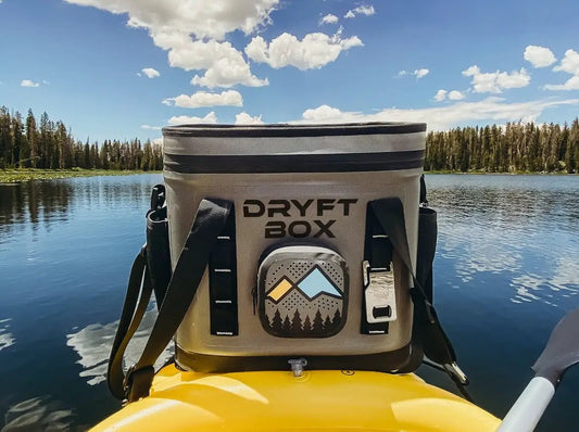 Dryft Box waterproof cooler with gray fabric and mountain graphic front pocket on a yellow kayak on Tampa Home & Garden Store