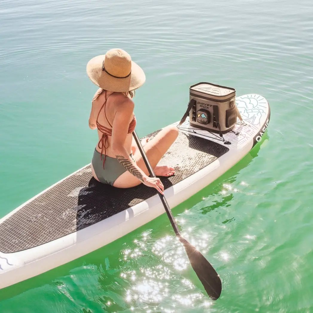 SolVida Dryft Box tan waterproof cooler with built-in Bluetooth speaker on a paddleboard on Tampa Home & Garden Store