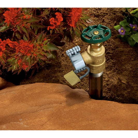 Double-Sided Hose Bib Lock Orbit Irrigation brass spigot with green handle in garden bed on Tampa Home & Garden Store
