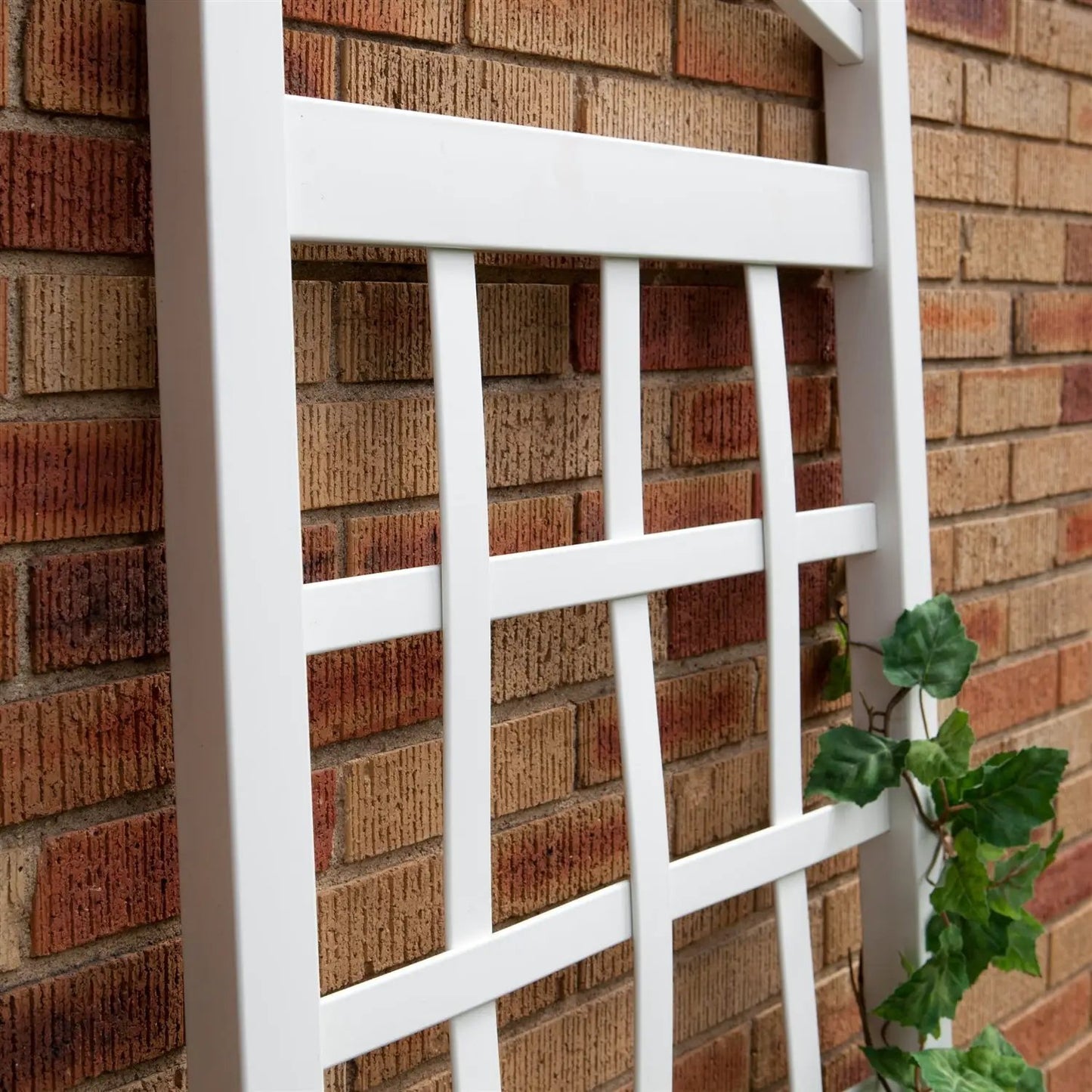 6 ft white vinyl garden trellis with arch top leaning against a brick wall on Tampa Home & Garden Store
