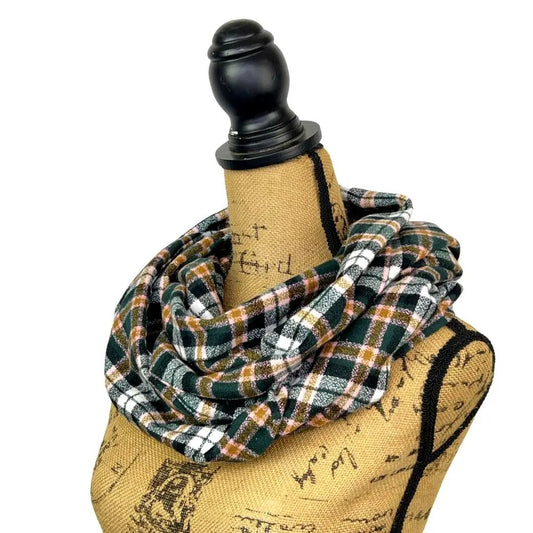 Infinity scarf in dark forest green melange plaid flannel displayed looped around a mannequin on Tampa Home & Garden Store